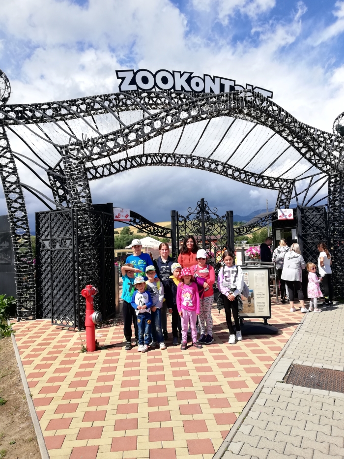 Skupina detí pred bránou s nápisom Zoo kontakt.