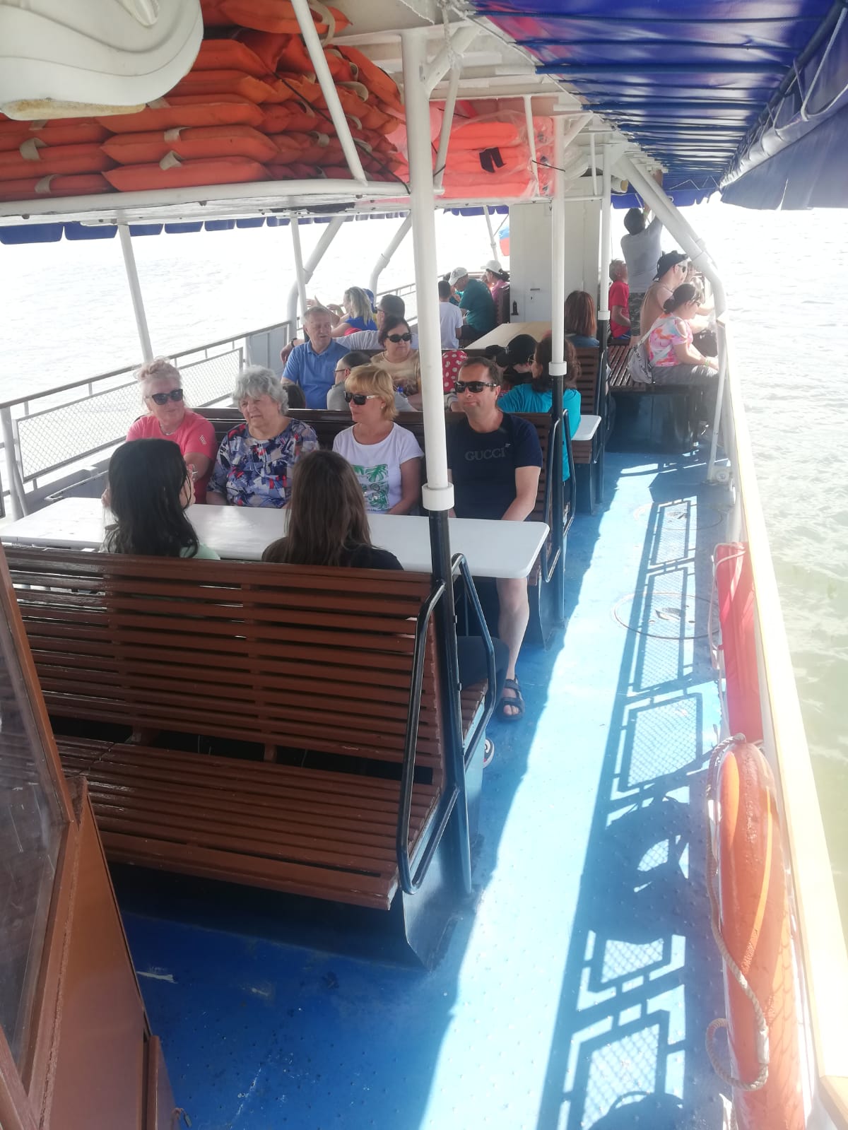 Skupina Členov sedí na lodi  počas plavby na Liptovskej Mare.